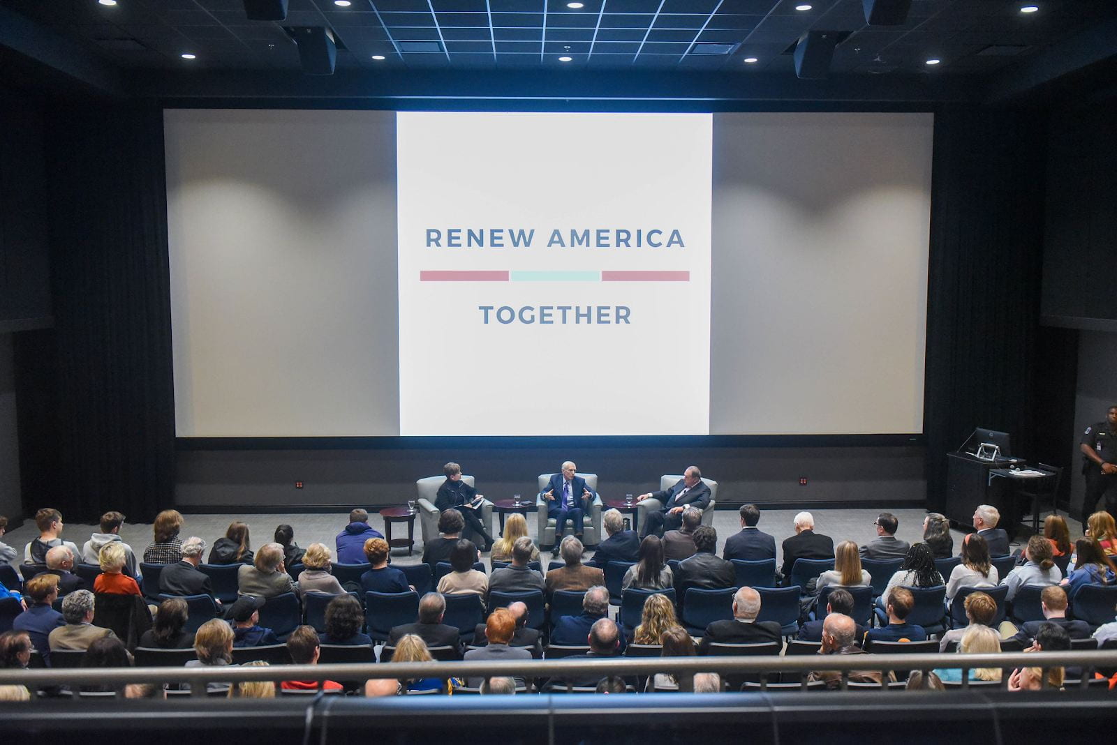 Audience members watch a discussion between Wesley Clarke and Mike Huckabee facilitates by "Renew America Together"
